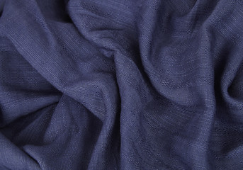 Fabric textures - a close up of navy blue scarf material folds to form a page background