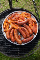 Sausages and bacon on grill tray