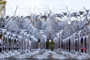 A lot of empty wine glasses in a row.
