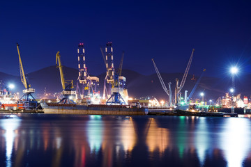 Fototapeta na wymiar Illuminated cargo port, ships and cranes.