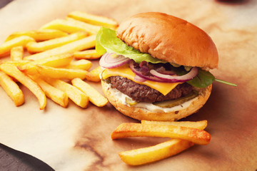 Delicious homemade hamburger with french fries on wooden vintage table