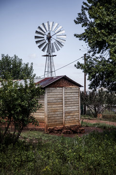 Wooden shack with windmill behind