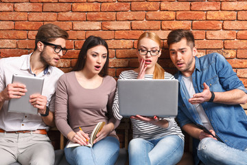 Shocked friends are using modern gadgets