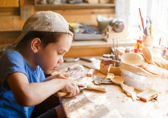boy learning wood carving. young carpenter working in a workshop