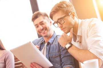 Cheerful young men discussing new project