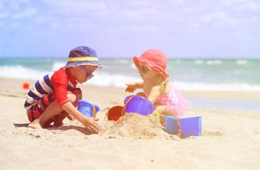 kids play with sand on summer beach