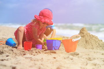 kids play with sand on summer beach