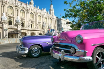 Tableaux ronds sur plexiglas Havana Two colorful vintage taxis and the Great Theater on the background in Havana, Cuba