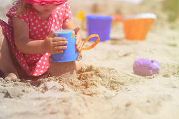 little girl play with sand on beach