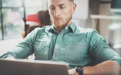 Fototapeta premium Bearded Businessman working Laptop modern Interior Design Loft Studio.Man sitting Vintage chair.Use contemporary Notebook, blurred background.Creative New business Startup Idea.Horizontal,film effect.