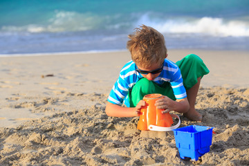 little boy play with sand on beach