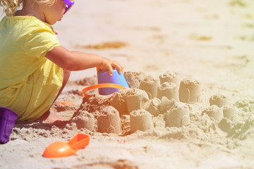 little girl play with sand on beach