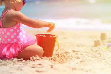 little girl play with sand on beach