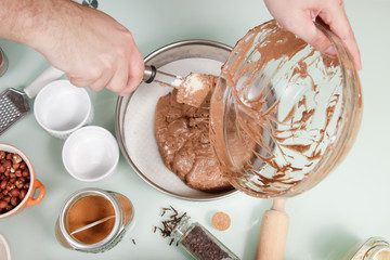 closeup hand transferring cake mixture cake pan