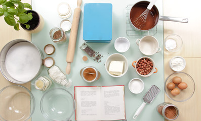 Fototapeta na wymiar Elevated view cook book table ingredients cups bowls