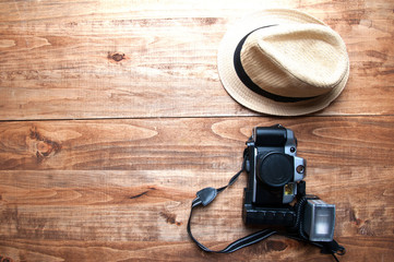 Tourism concept. Hat and old camera isolated on wooden backgroun