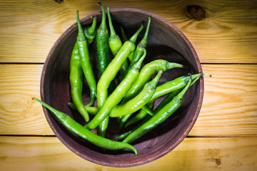  Large green pepper in wood bowl.