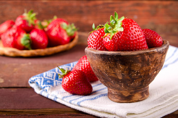Ripe fresh juicy organic strawberries in old clay bowl