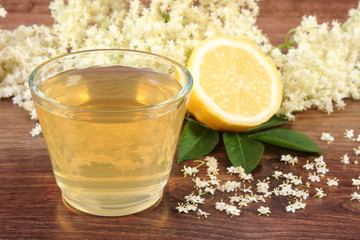 Fresh healthy juice, elderberry flowers and lemon on rustic board