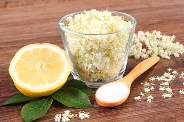 Elderberry flowers and ingredients for preparing juice on rustic board