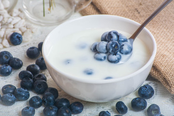 Juicy and fresh blueberries on the spoon with yogurt