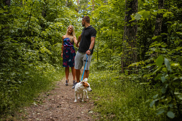 Fototapeta premium Attractive couple on a walk with a dog.