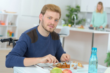 Disabled man having lunch at home