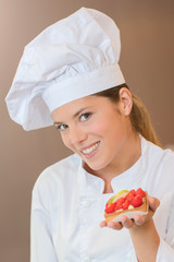 Baker holding strawberry tart