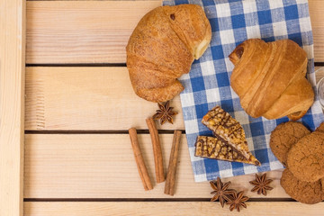 fresh pastries on a wooden background. blue napkin. croissant