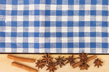anise and cinnamon on a blue napkin, wooden background