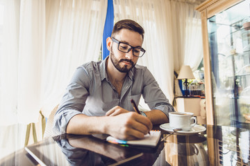 Businessman in a cafe drinking coffee and working on a Tablet PC