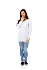 Young woman giggles covering her mouth with hand