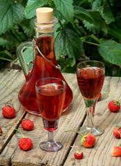 homemade strawberry liquor on a wooden background