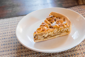 A slice of Almonds pie, on a plate and ready to eat