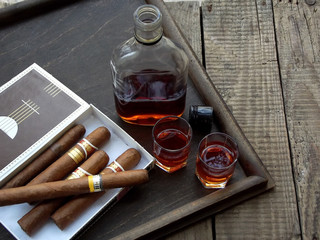 quality cigars and cognac on an old wooden table - obrazy, fototapety, plakaty