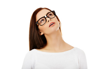 Young beautiful woman thinking looking up