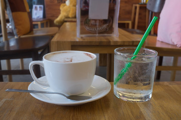 hot fresh coffee in white cup on wooden table with cold glass of water cappuccino coffee mocha coffee espresso coffee latte coffee