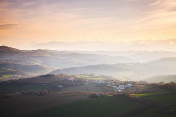 Villages and on hills under colorful cloudy sky, Italy