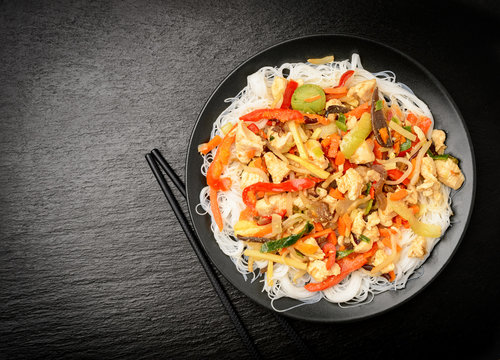 Rice noodles with vegetables, mushrooms, chicken and soy sauce.