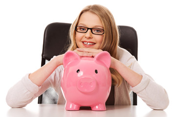 Young woman with piggybank on the desk