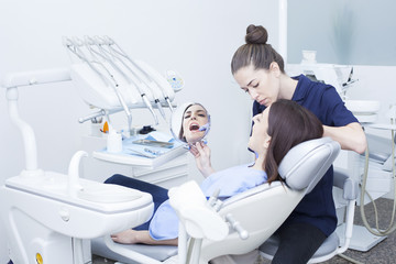 Obraz premium Beautiful woman patient having dental treatment at dentist's office. Woman visiting her dentist