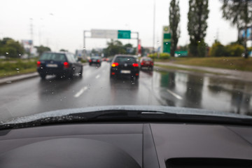 Fototapeta na wymiar Driving a car in bad weather conditions in traffic jam - blurred view