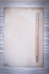 Vintage paper sheet pencil on wooden board