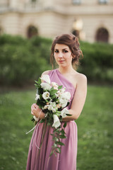 Beautiful bride, girl outdoors posing with bouquet