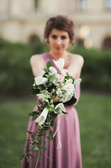 The beautiful woman, bride in pink dress with great bouquet
