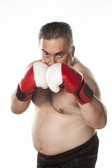 Serious fat man with boxing gloves in guard