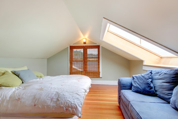 Upstairs bedroom with vaulted ceiling and hardwood floor.