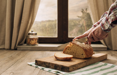 Man cutting a loaf of fresh bread