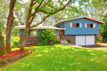 Blue brick American rambler exterior with nice front garden. - obrazy, fototapety, plakaty