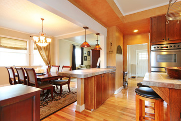 House interior with open wall design. View of dining table set and kitchen room.